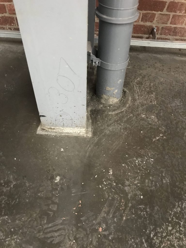 The concrete encapsulates the column and drain pipe without cracks propagating.