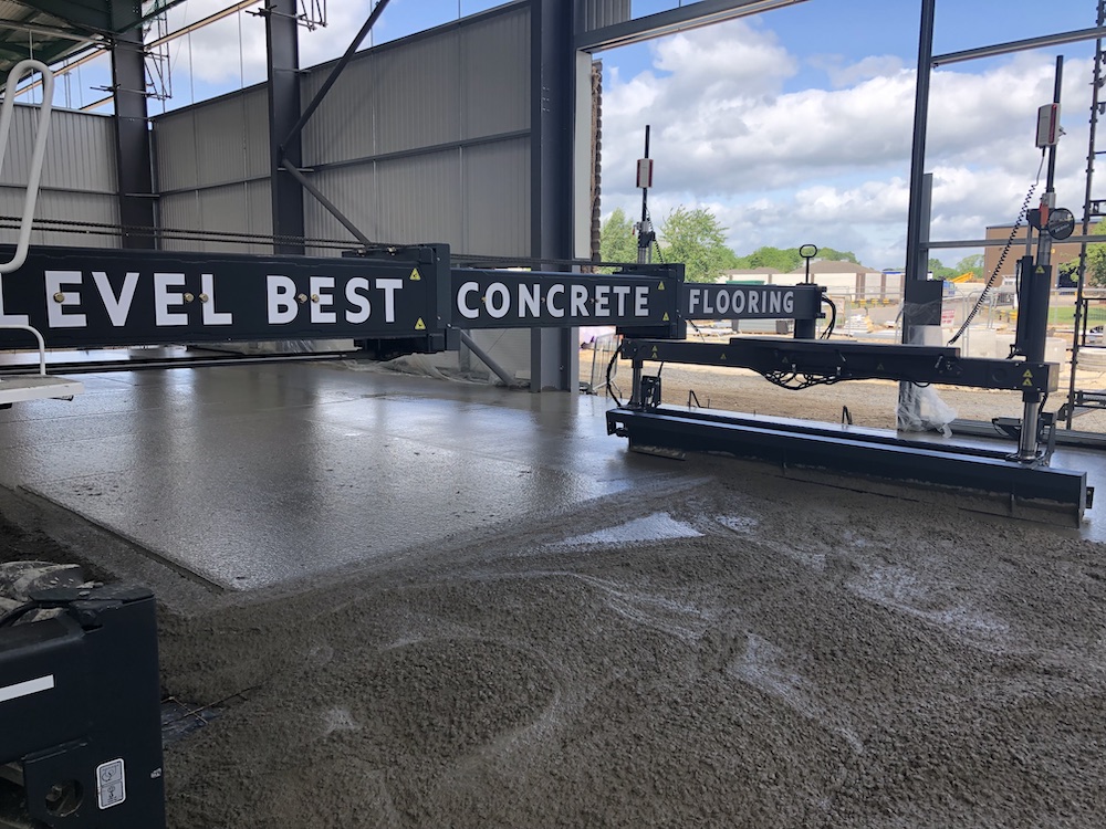 Somero laser screed in operation laying a new cast insitu warehouse concrete floor slab in Dagenham, East London.